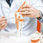 médico mostrando rodilla
